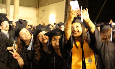 Graduates take selfies before the ceremony.