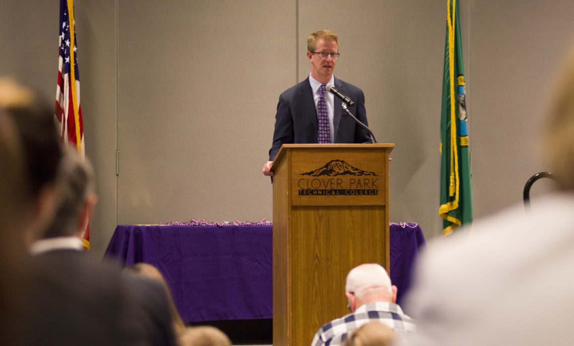 Congressman Derek Kilmer speaks at podium.