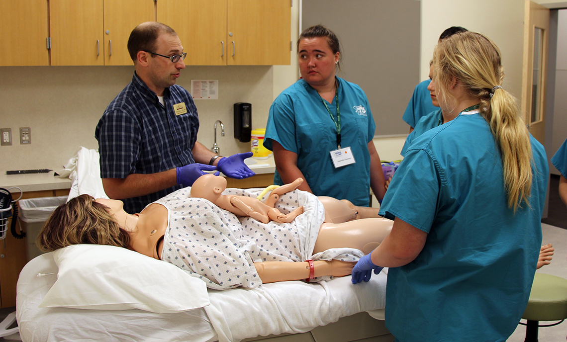 CPTC Nursing instructor David Bahrt discusses the birthing process with Nurse Camp attendees following a simulated birth.