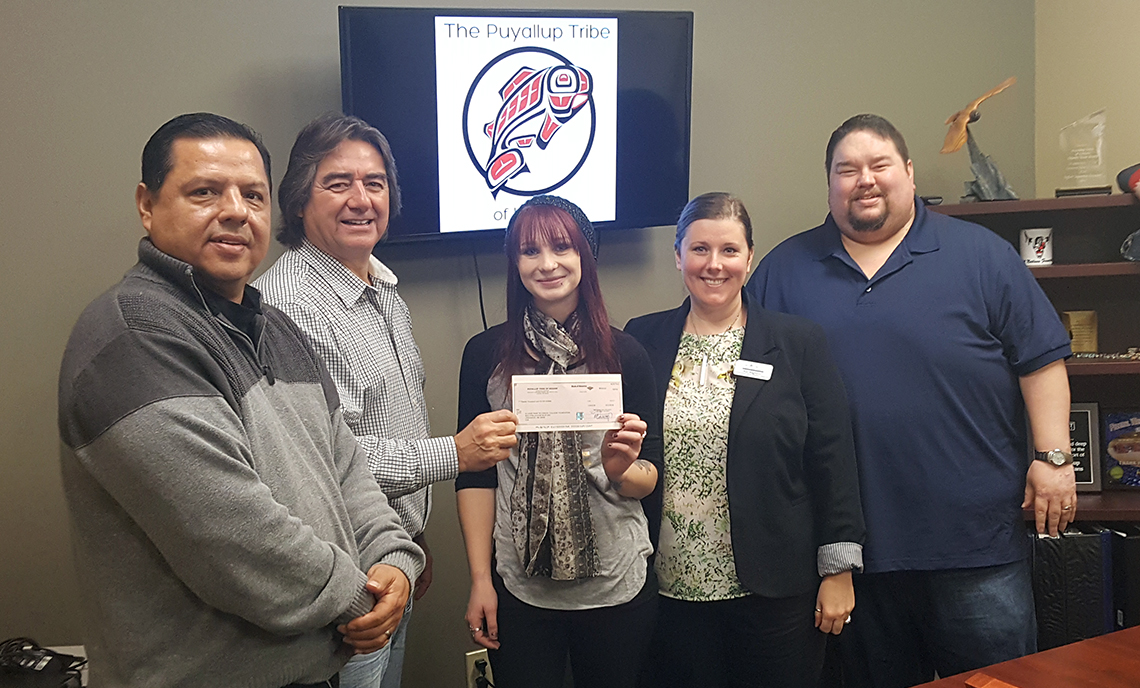 Puyallup Tribe chairman Don Coats, commissioner Brandon Reynon and vice-chair James Miles present the grant check to Heather Morgan and Rae Baghirov from the CPTC Foundation on Friday, Feb. 2.