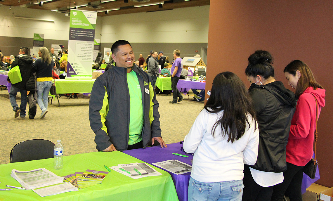 CPTC Entry Services Specialist Kiko Salas speaks with visitors at CPTC's Program Expo on Wednesday, April 11, at the McGavick Conference Center.