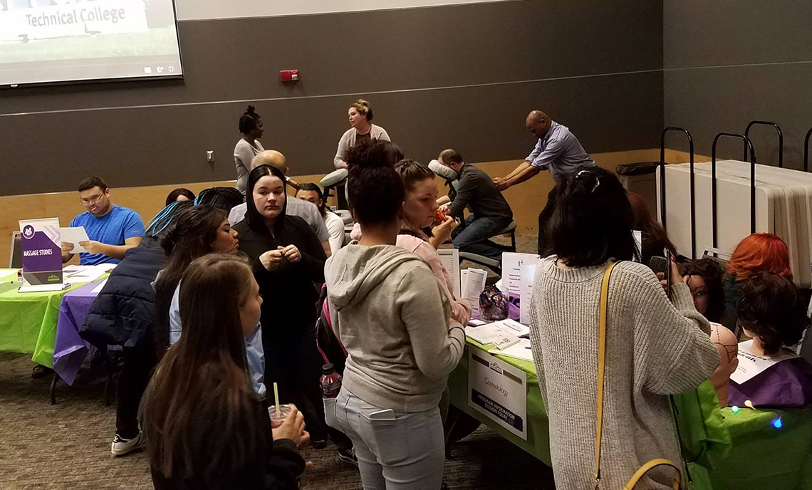 Visitors to CPTC's Fall Program Expo check out the Cosmetology and Massage Studies tables.