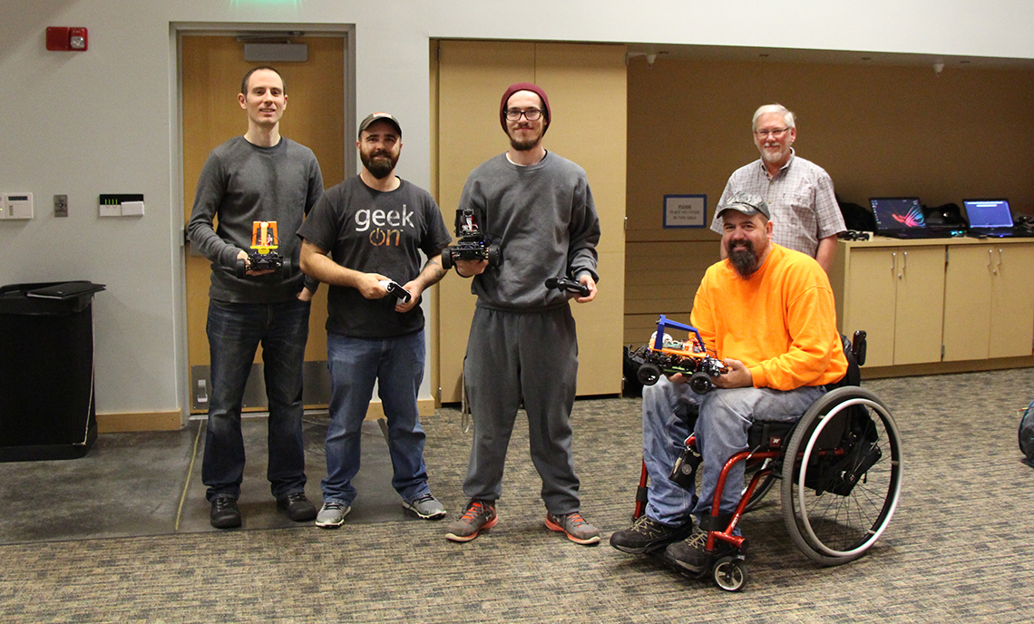 CPTC computer programming students (from left to right) Chad Drennan, Anthony McCann, Dakota Tominus, and Robert Wood join instructor Ken Meerdink to experiment with training their Donkey Cars.