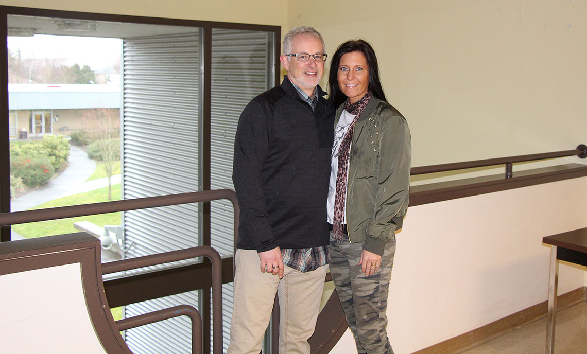 Clover Park alumni Geoff and Tara Waits stand at the upstairs landing in Building 19, where they met in the late-1980s as students.