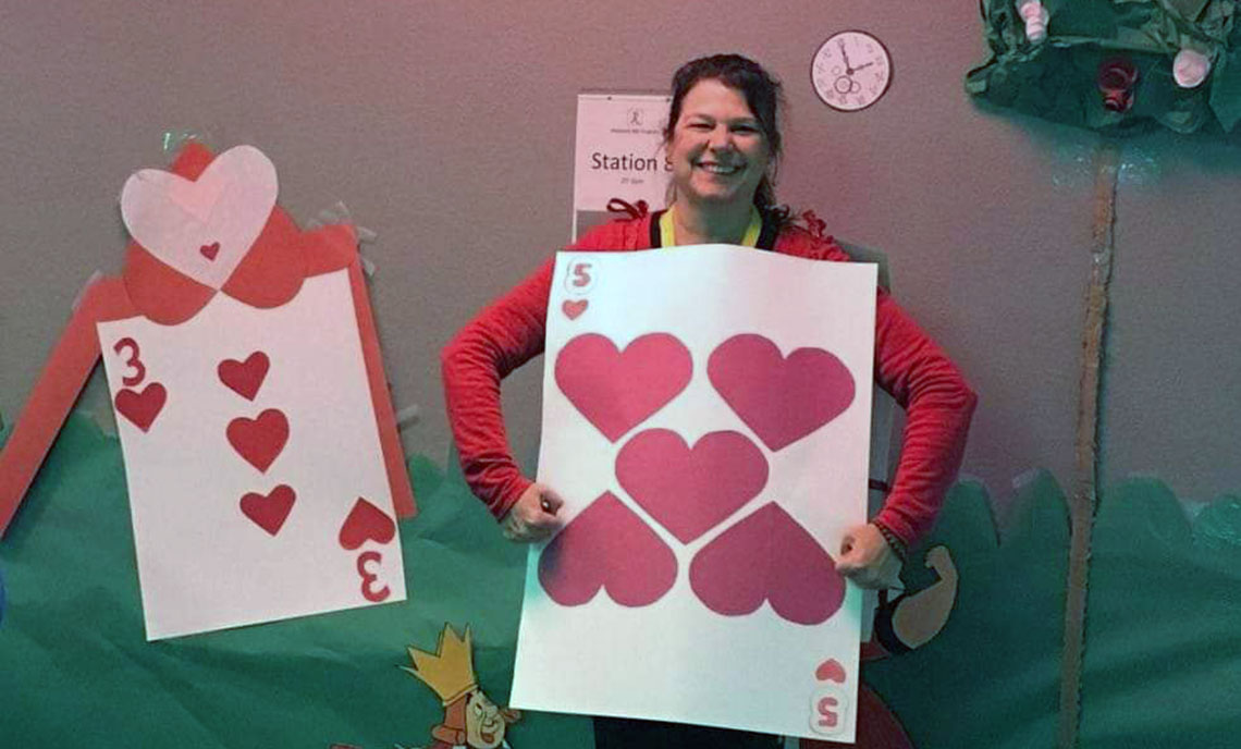 Woman dressed in "Alice in Wonderland" card soldier costume for Halloween.