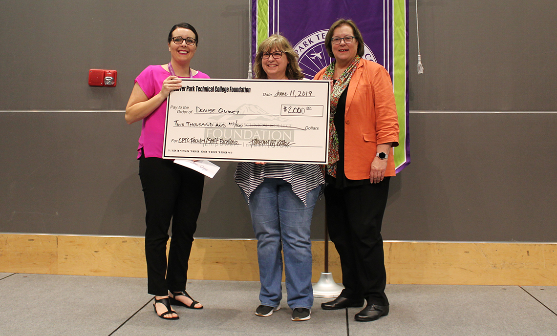 Three women holding a giant check