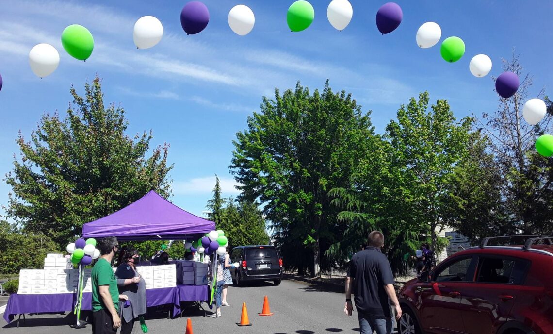 Arch of purple white and green ballons marking the starting line