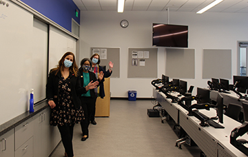 Claire Korschinowksi, Marilyn Strickland and Dr.Loveday waving in classroom