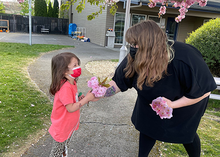 Rachael Butler handing a little girl flowers