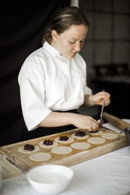 Inessa Suparscaia scooping berries onto a tray of tarts