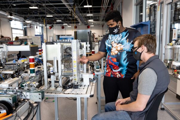 two students at mechatronics device