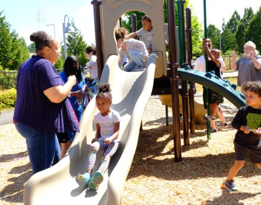 Children playing on a slide and climbing structure at the Hayes Child Development Center at CPTC