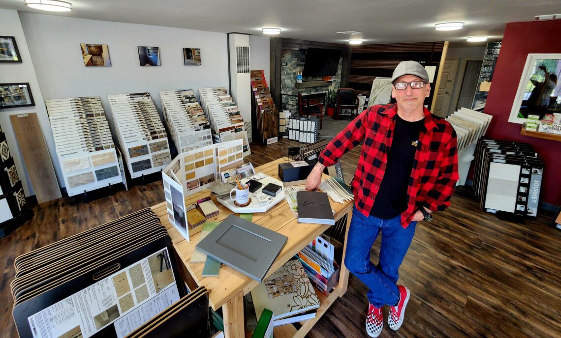 CPTC alumnus Gerald Carver in his design shop, NW Creations. Behind him are displays of samples for decorating homes.