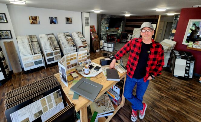CPTC alumnus Gerald Carver in his design shop, NW Creations. Behind him are displays of samples for decorating homes.