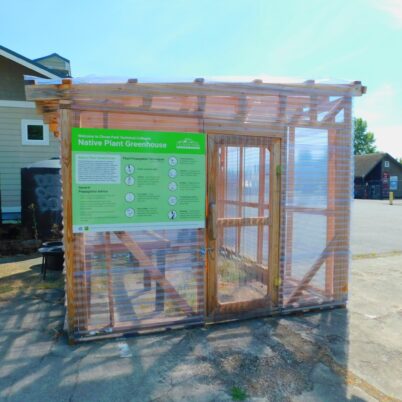 Photo Marcia Wilson. The CPTC greenhouse. Behind it is the water tank that collects rain from the roof of the Zero Energy House